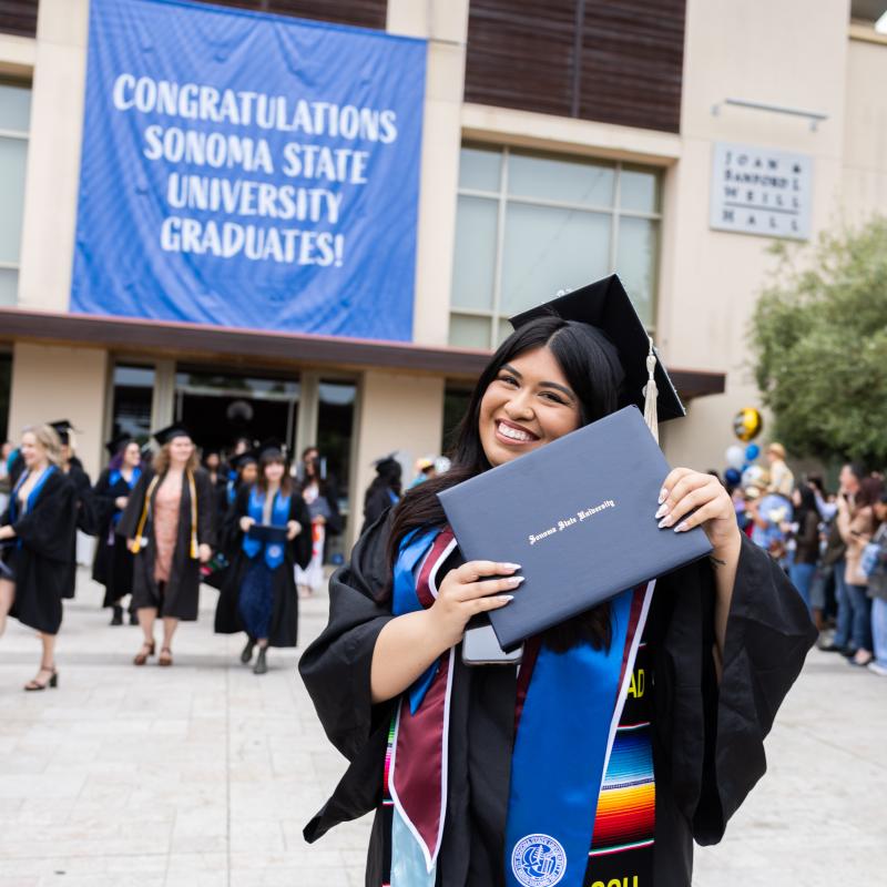 Graduate holding their diploma