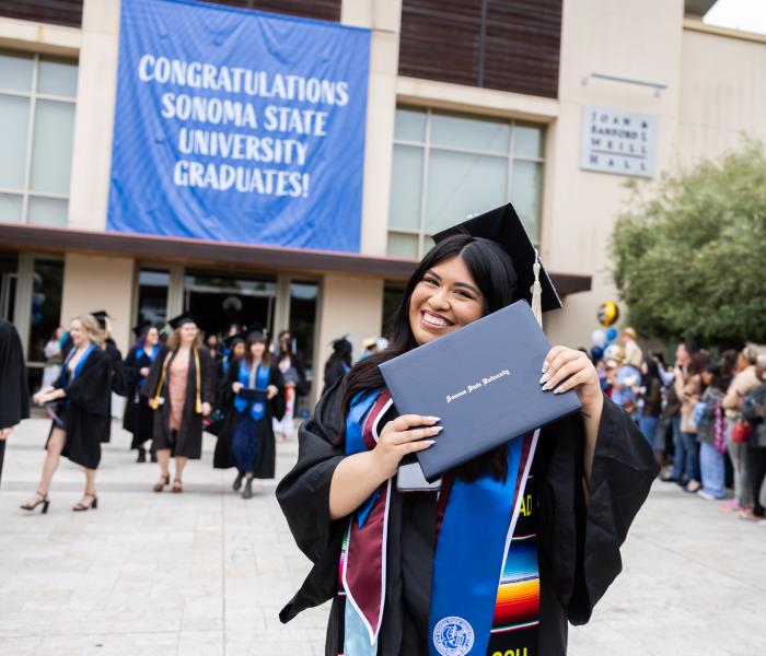 Graduate holding their diploma