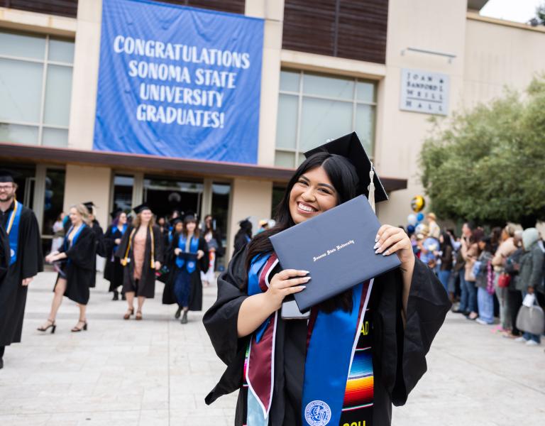 Graduate holding their diploma